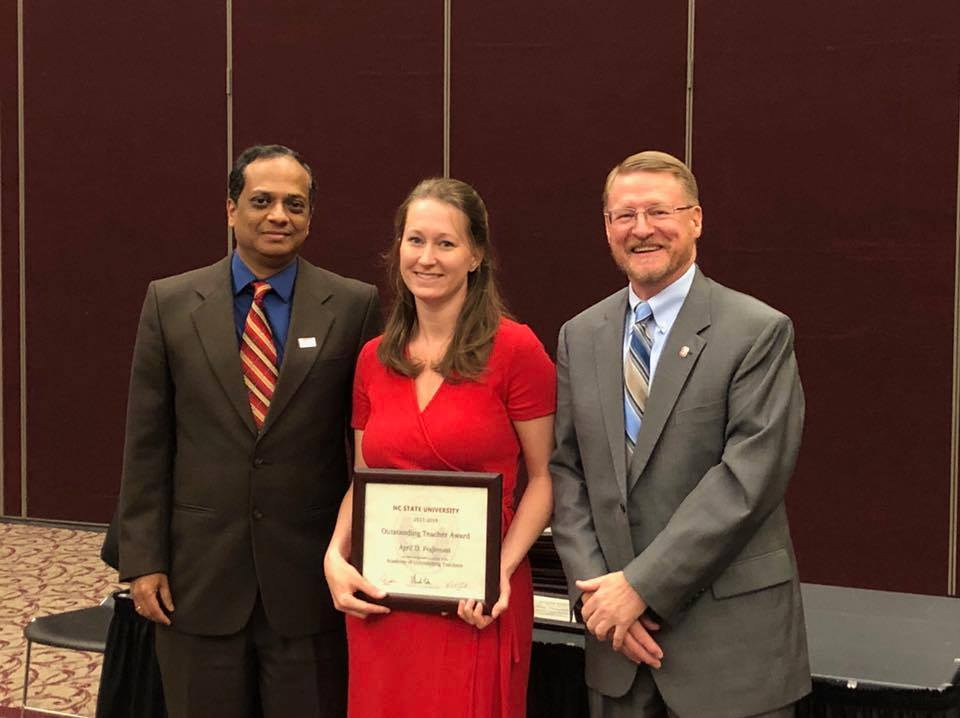 Dr. April Fogleman, center, accepts an Outstanding Teacher Award.