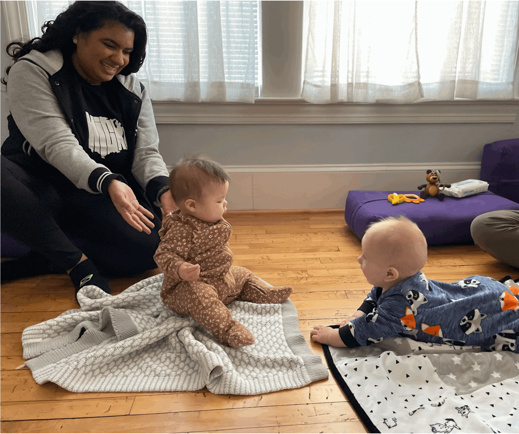 A mother encourages her child to play with another baby during a play date. Support of Breastfeeding